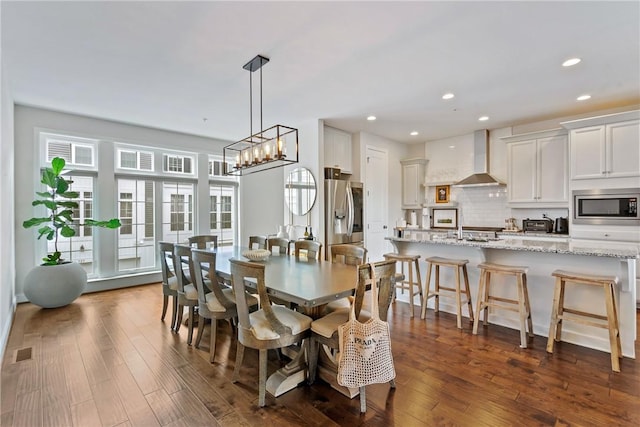 dining room with a notable chandelier and dark hardwood / wood-style flooring