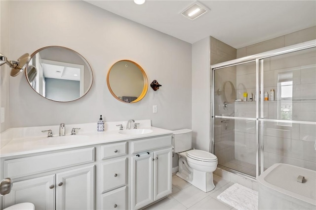 bathroom with tile patterned flooring, vanity, a shower with shower door, and toilet