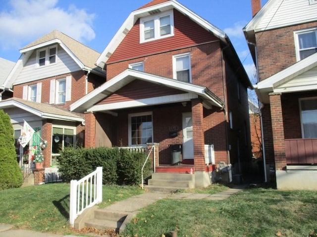 view of front of home with covered porch and a front yard