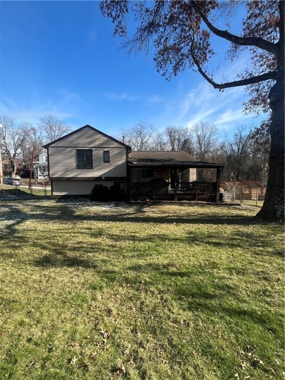 rear view of house featuring a yard