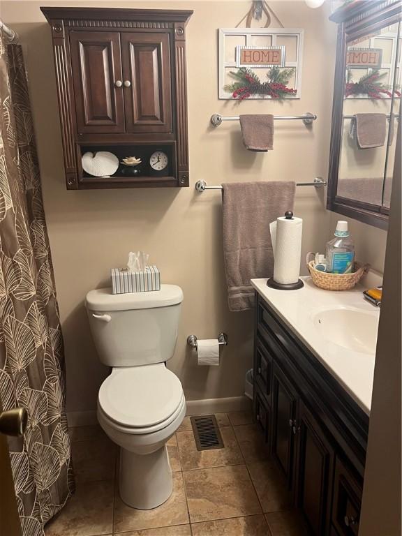 bathroom featuring tile patterned floors, vanity, and toilet