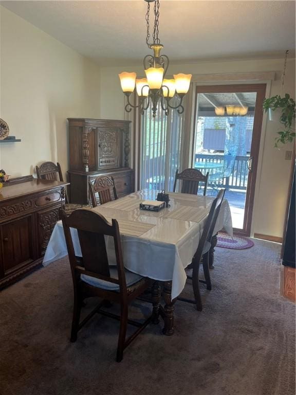 dining area featuring dark carpet and an inviting chandelier