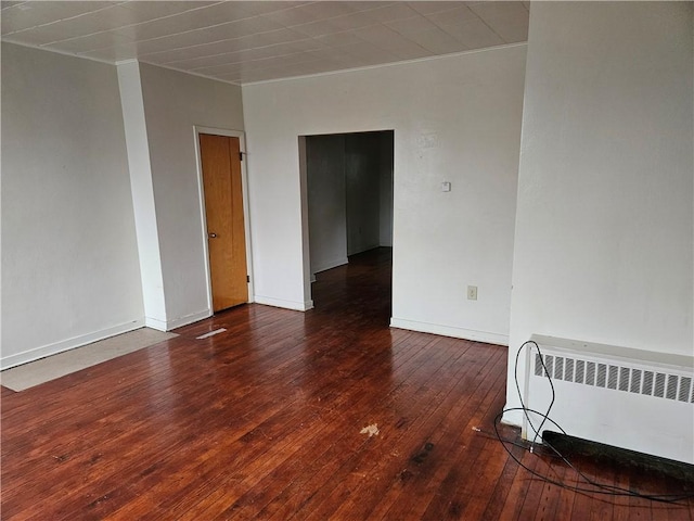 unfurnished room featuring dark hardwood / wood-style flooring and radiator