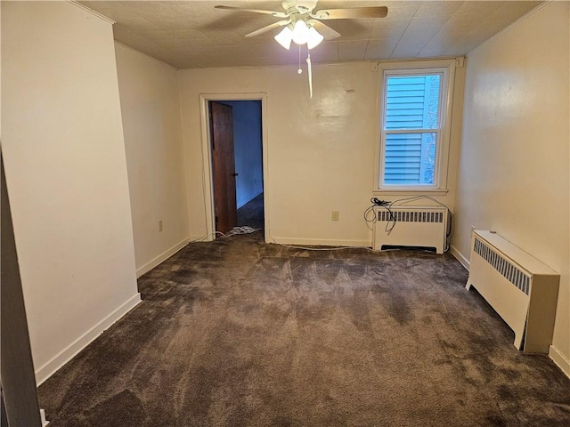 empty room featuring a textured ceiling, dark carpet, radiator, and ceiling fan