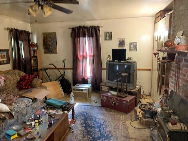 living room featuring ceiling fan and a brick fireplace