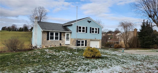 view of front of property featuring a garage and a front lawn