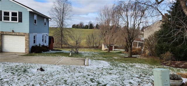 snowy yard featuring a garage