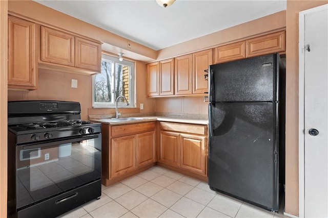 kitchen featuring sink, light tile patterned floors, and black appliances