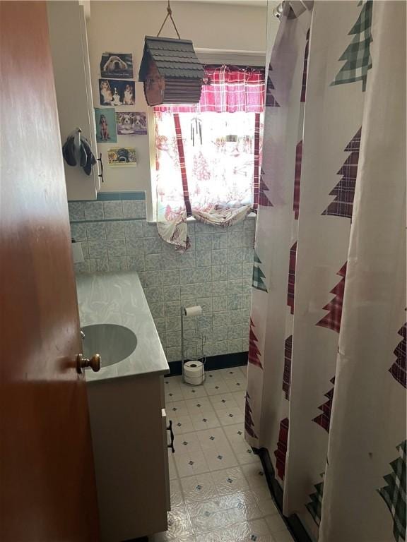 bathroom featuring vanity and tile walls