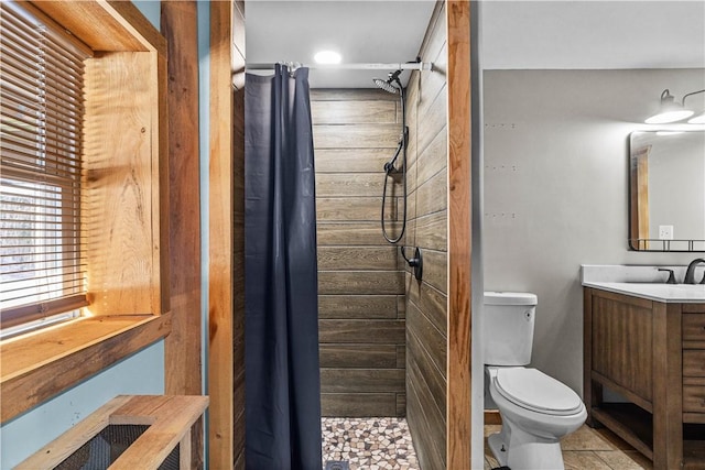 bathroom with tile patterned flooring, vanity, toilet, and curtained shower