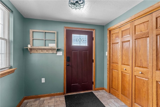 foyer entrance with a textured ceiling and a healthy amount of sunlight