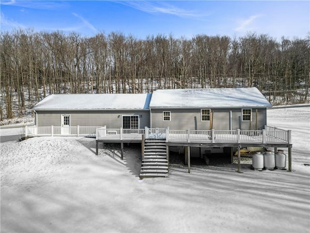 snow covered house with a wooden deck