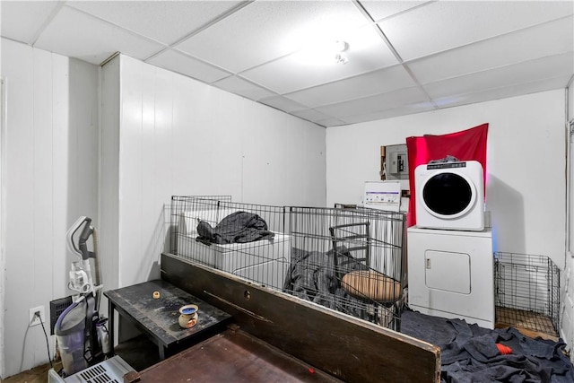 washroom featuring stacked washer / dryer and wooden walls