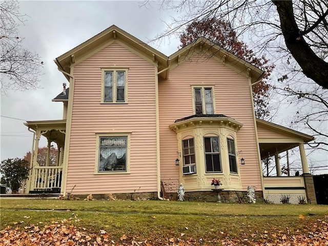 back of house featuring a lawn and a porch