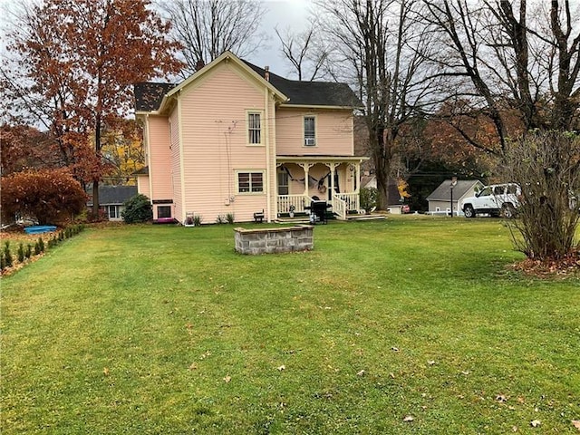 back of property with covered porch and a yard