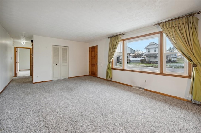 interior space with a textured ceiling and carpet floors