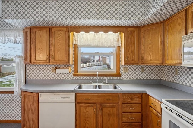 kitchen with decorative backsplash, white appliances, a wealth of natural light, and sink