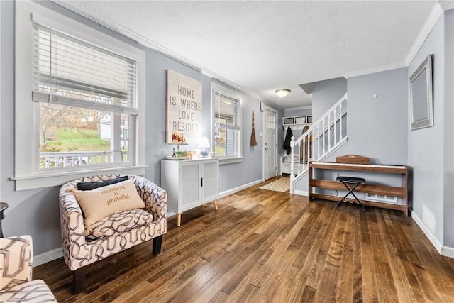 living area featuring hardwood / wood-style floors, a textured ceiling, and ornamental molding