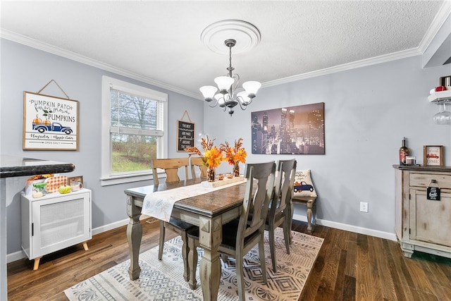 dining room with a textured ceiling, dark hardwood / wood-style flooring, crown molding, and an inviting chandelier