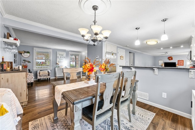 dining area with a textured ceiling, a chandelier, dark hardwood / wood-style floors, and ornamental molding