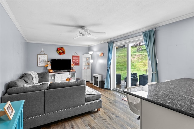 living room featuring hardwood / wood-style floors, ceiling fan, and ornamental molding