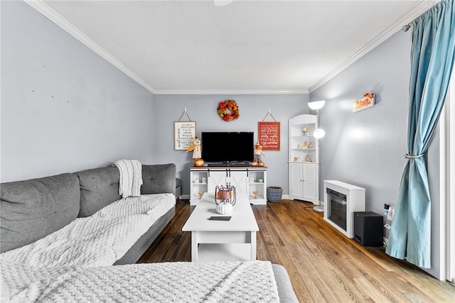 living room featuring hardwood / wood-style flooring, crown molding, and a textured ceiling