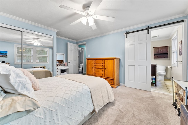 carpeted bedroom with ceiling fan, a barn door, crown molding, and ensuite bath