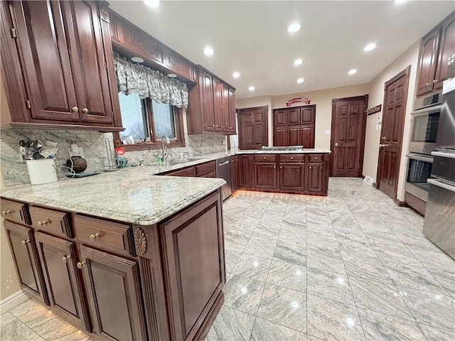 kitchen featuring backsplash, kitchen peninsula, sink, and stainless steel appliances