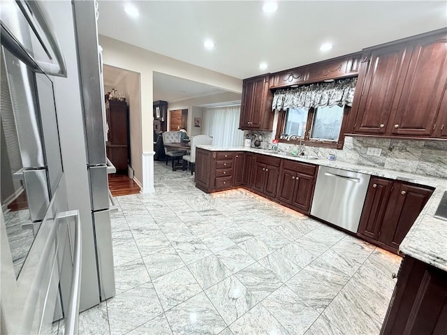 kitchen featuring appliances with stainless steel finishes, backsplash, dark brown cabinets, and sink