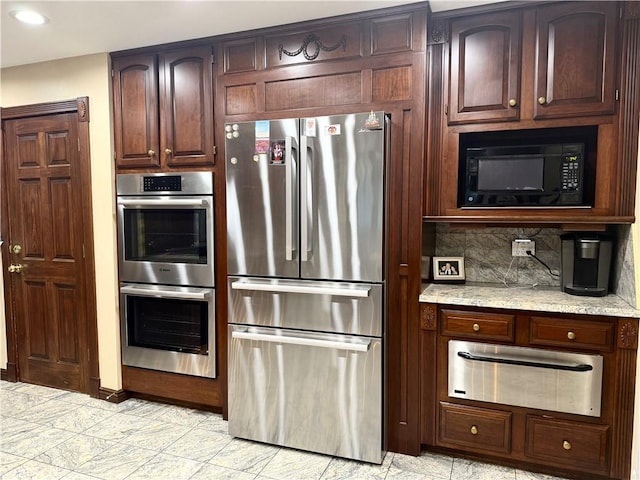 kitchen with light stone counters, backsplash, and appliances with stainless steel finishes