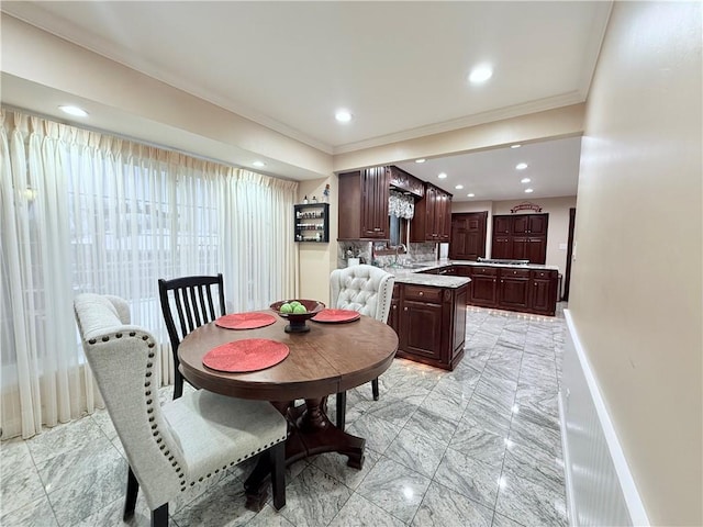 dining area featuring sink and ornamental molding