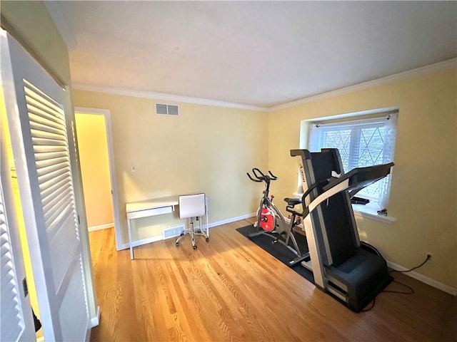 workout area with wood-type flooring and ornamental molding