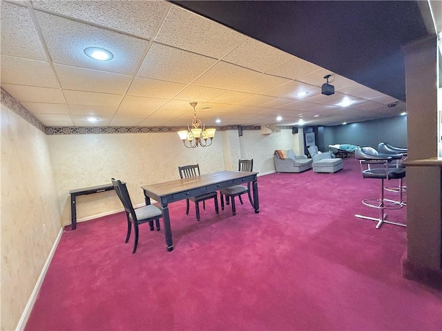 dining area with a paneled ceiling, a notable chandelier, and carpet floors