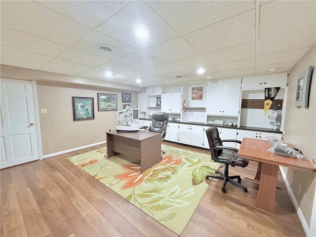 office space featuring light wood-type flooring and a drop ceiling