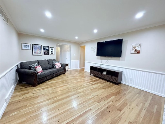 living room with ornamental molding and light wood-type flooring