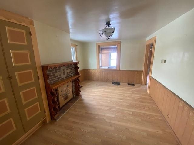 hallway with wooden walls and light hardwood / wood-style floors