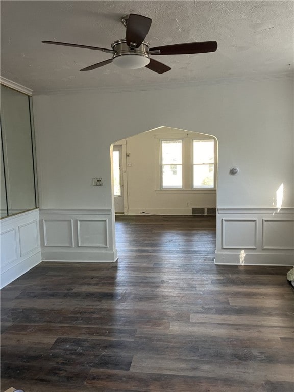 spare room featuring a textured ceiling, crown molding, ceiling fan, and dark hardwood / wood-style floors