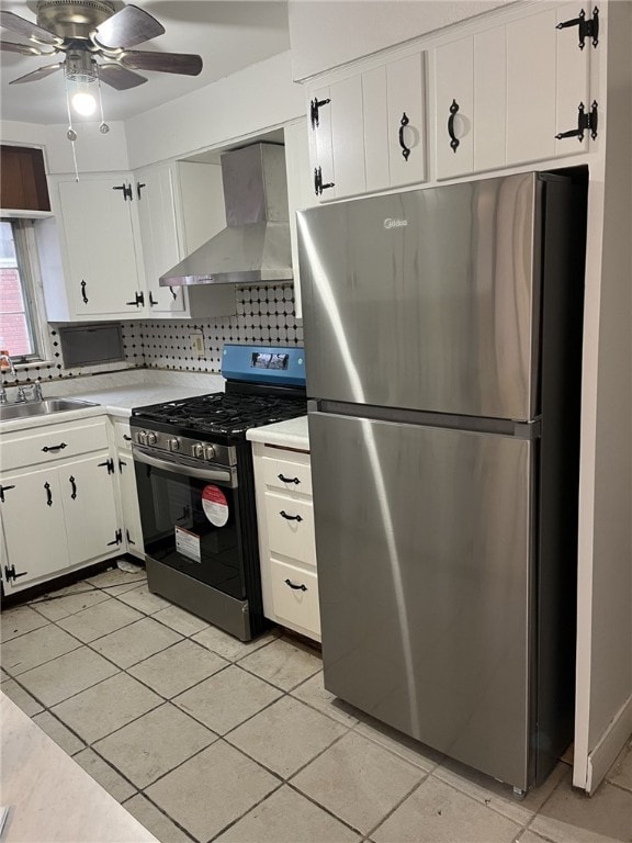 kitchen featuring decorative backsplash, wall chimney exhaust hood, stainless steel appliances, sink, and white cabinetry