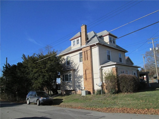 view of property exterior featuring a yard and central AC