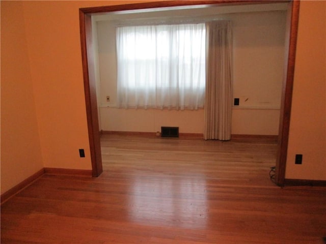 unfurnished room with hardwood / wood-style flooring