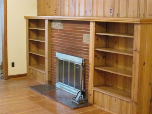 unfurnished living room featuring a brick fireplace and light hardwood / wood-style flooring