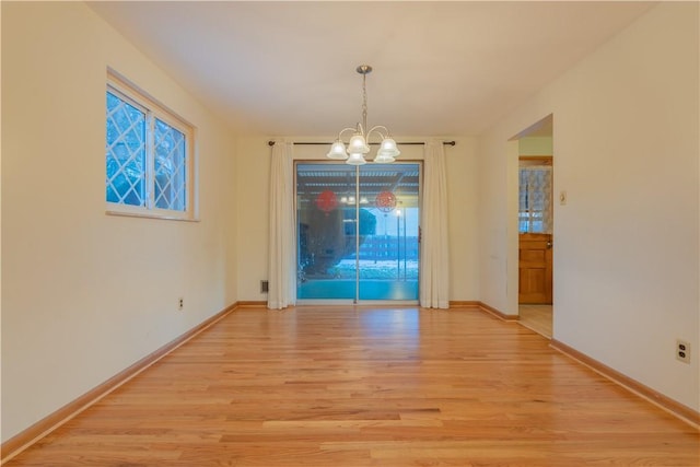 unfurnished dining area featuring light wood-type flooring and a notable chandelier