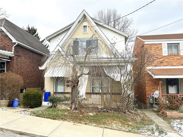 view of front facade with a porch, brick siding, and a balcony