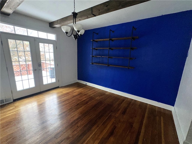 unfurnished dining area featuring beamed ceiling, a notable chandelier, wood-type flooring, and french doors