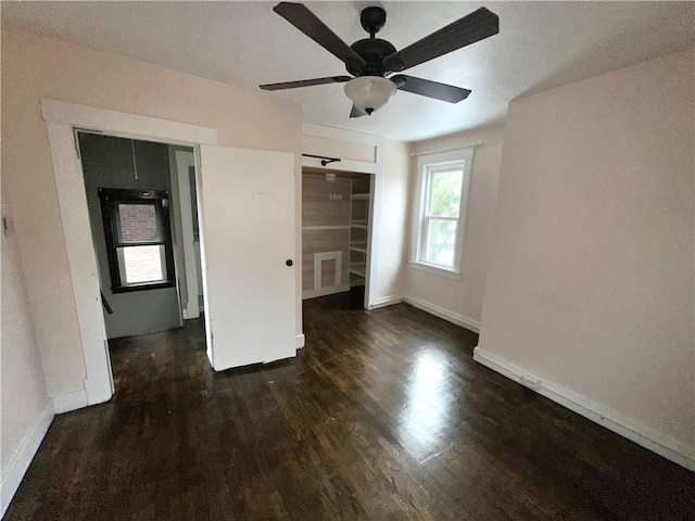 unfurnished bedroom with a closet, dark hardwood / wood-style floors, and ceiling fan