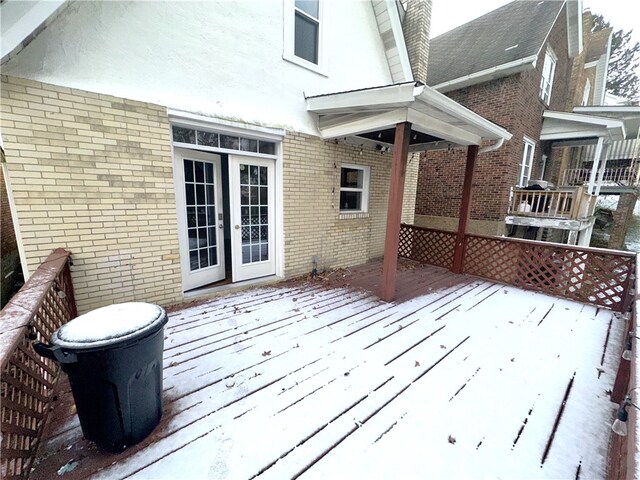 snow covered deck featuring french doors