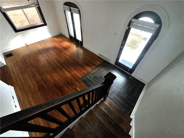 foyer entrance with dark hardwood / wood-style flooring and a healthy amount of sunlight