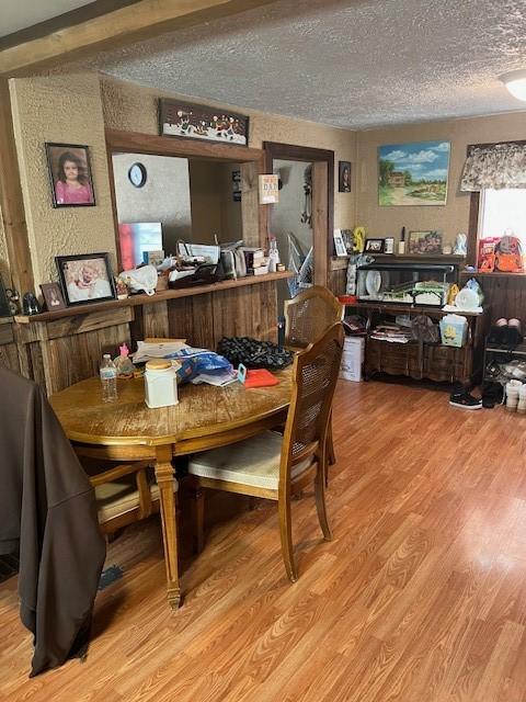 dining room with hardwood / wood-style floors and a textured ceiling