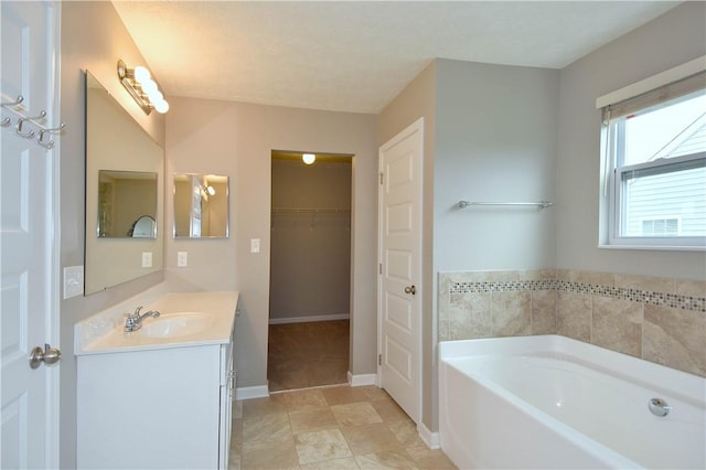 bathroom with tile patterned floors, a bathtub, and vanity