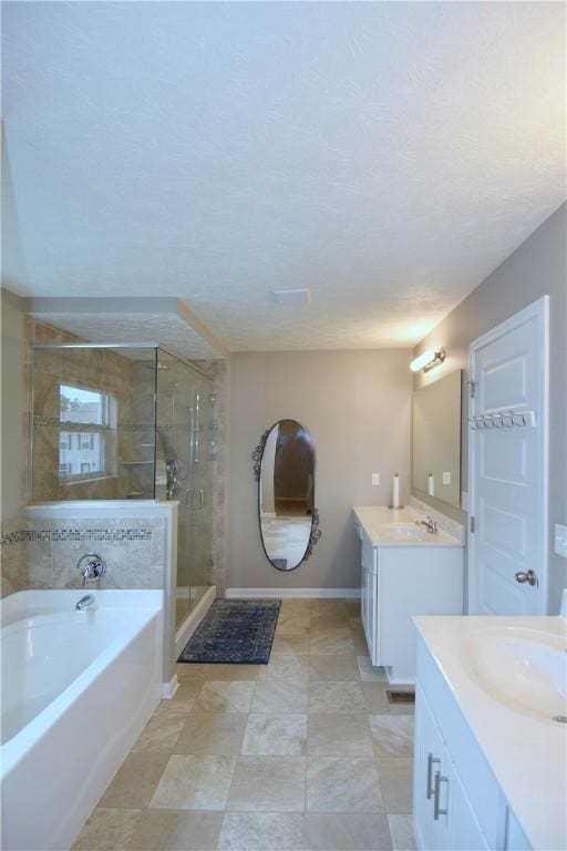 bathroom featuring plus walk in shower, vanity, and a textured ceiling